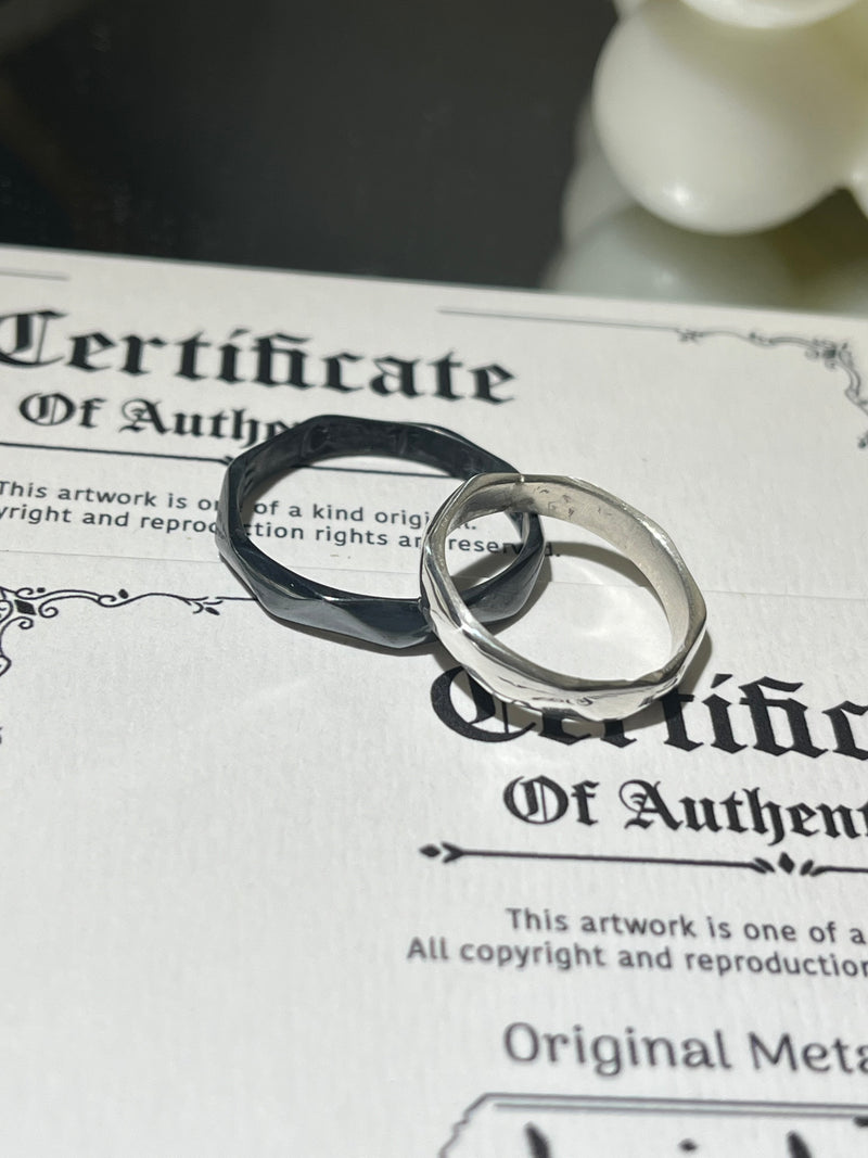 Faceted silver rings on a certificate