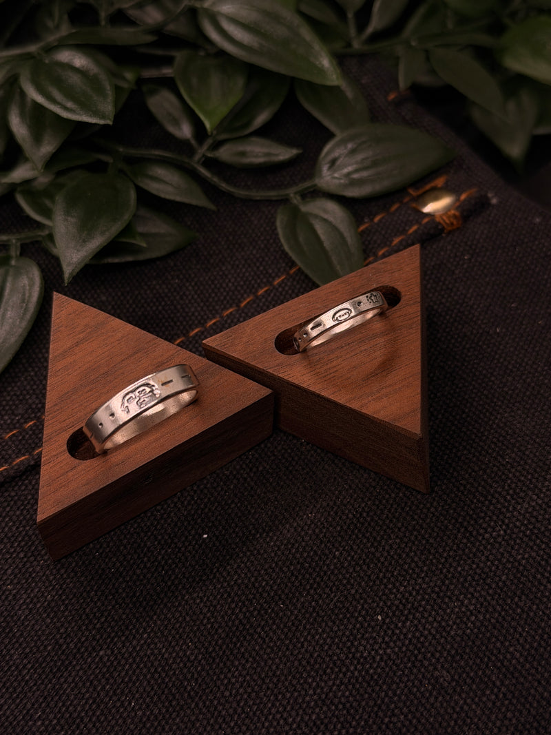 Stamped silver rings in wooden holders